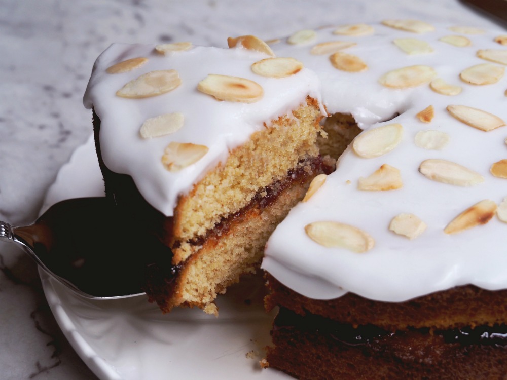 cutting slice from cherry bakewell cake