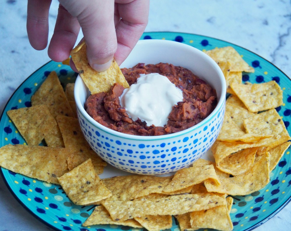 tortila chip dipped into mexican bean dip