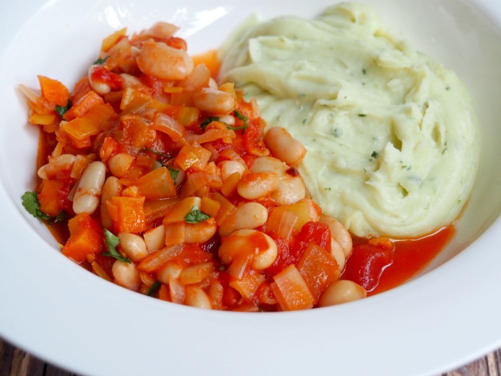 bean and cider stew with cheddar and parsley mash on a plate