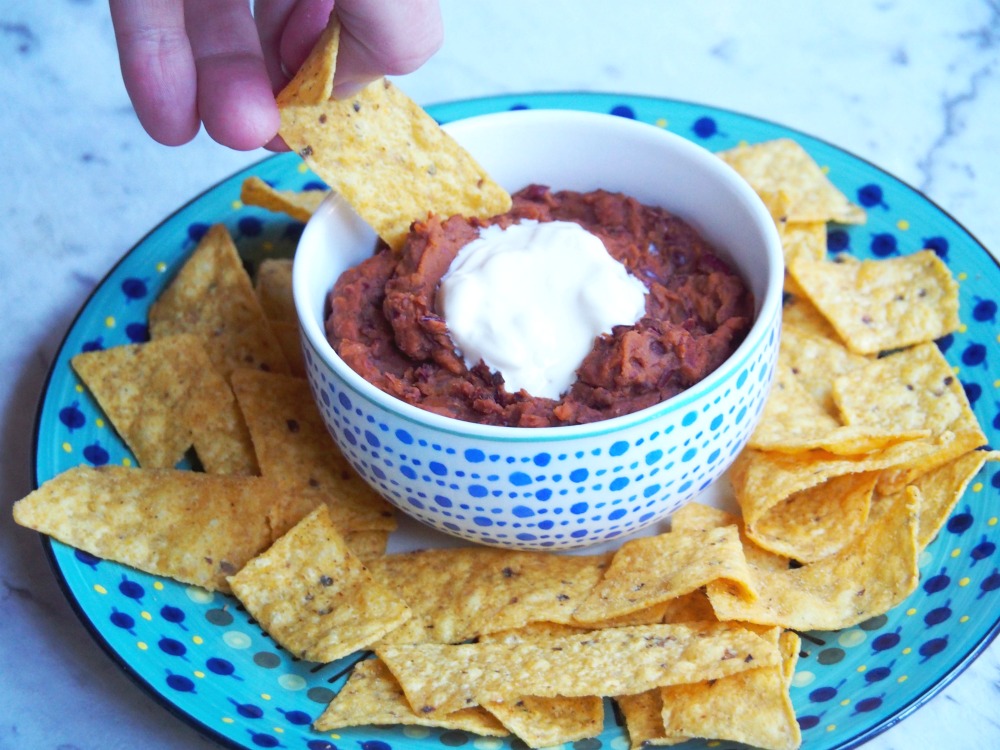 tortilla chip dipped in Mexican bean dip