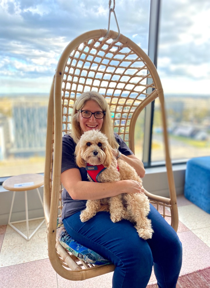 woman holding cavoodle in swinging chair