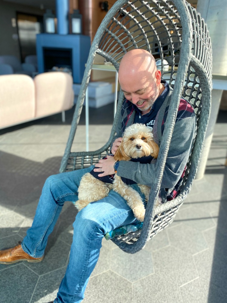 man and dog sitting in pod chair