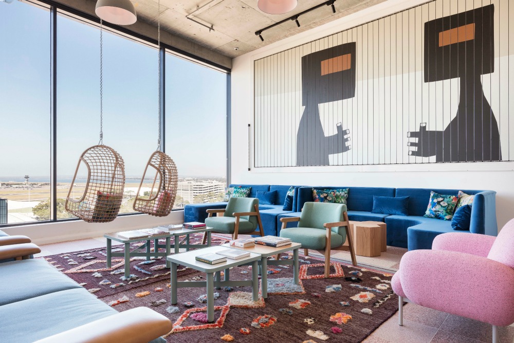 hotel lounge with modern rugs and light wood table and chairs 