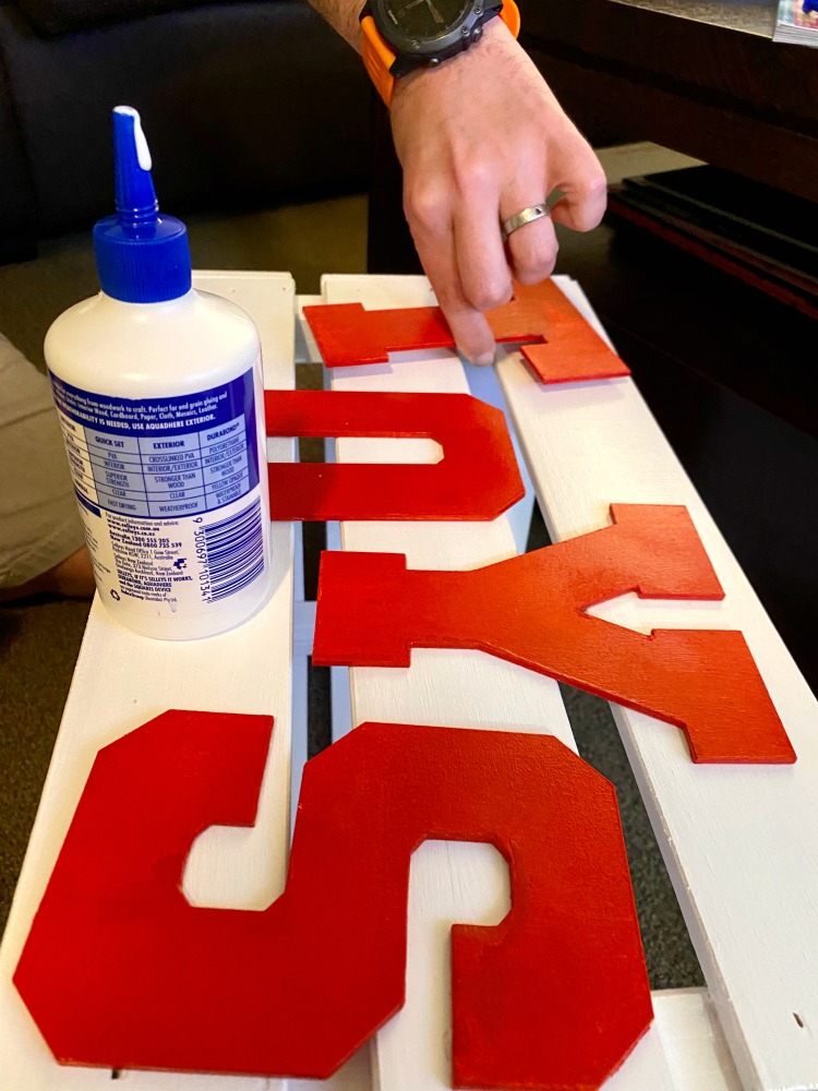 sticking letters on to wooden toy box