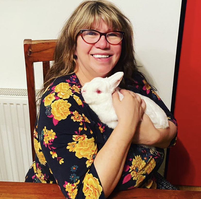 woman wearing glasses and holding a white rabbit