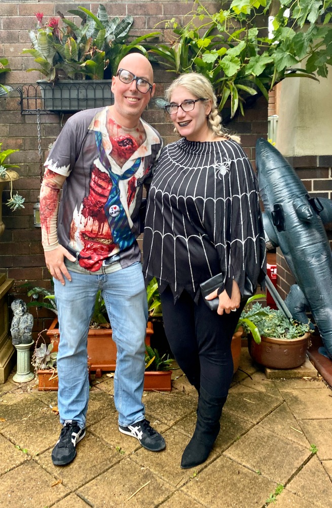 man dressed as zombie and woman wearing spider web poncho