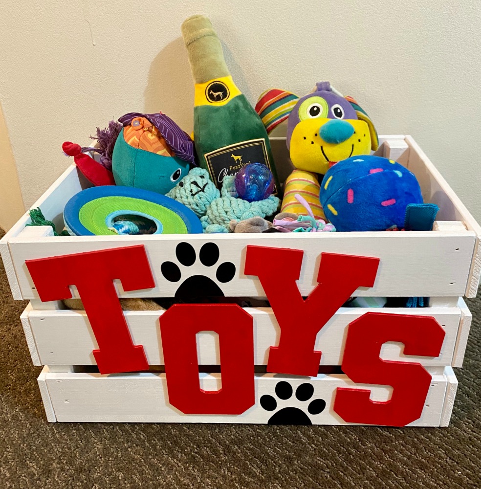 white toy box with red writing spelling toys