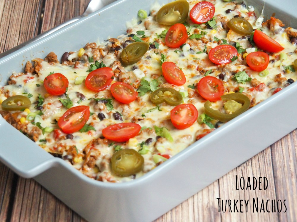 loaded turkey nachos topped with tomatoes cheese and jalapenos