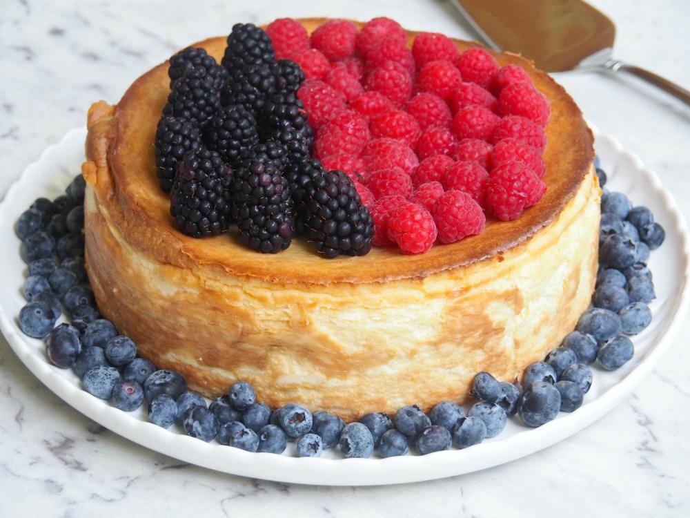 crustless baked cheesecake on white plate topped with blackberries and raspberries