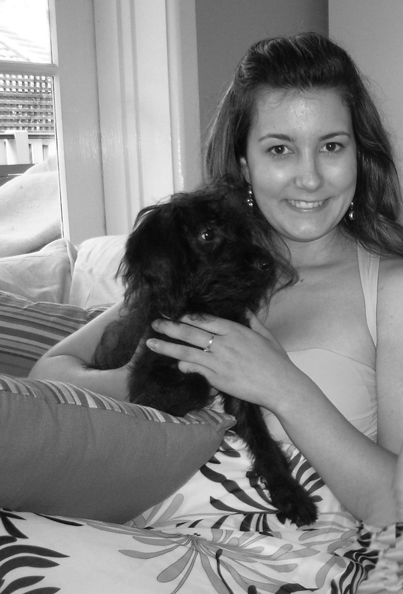 black and white picture of woman cuddling black dog