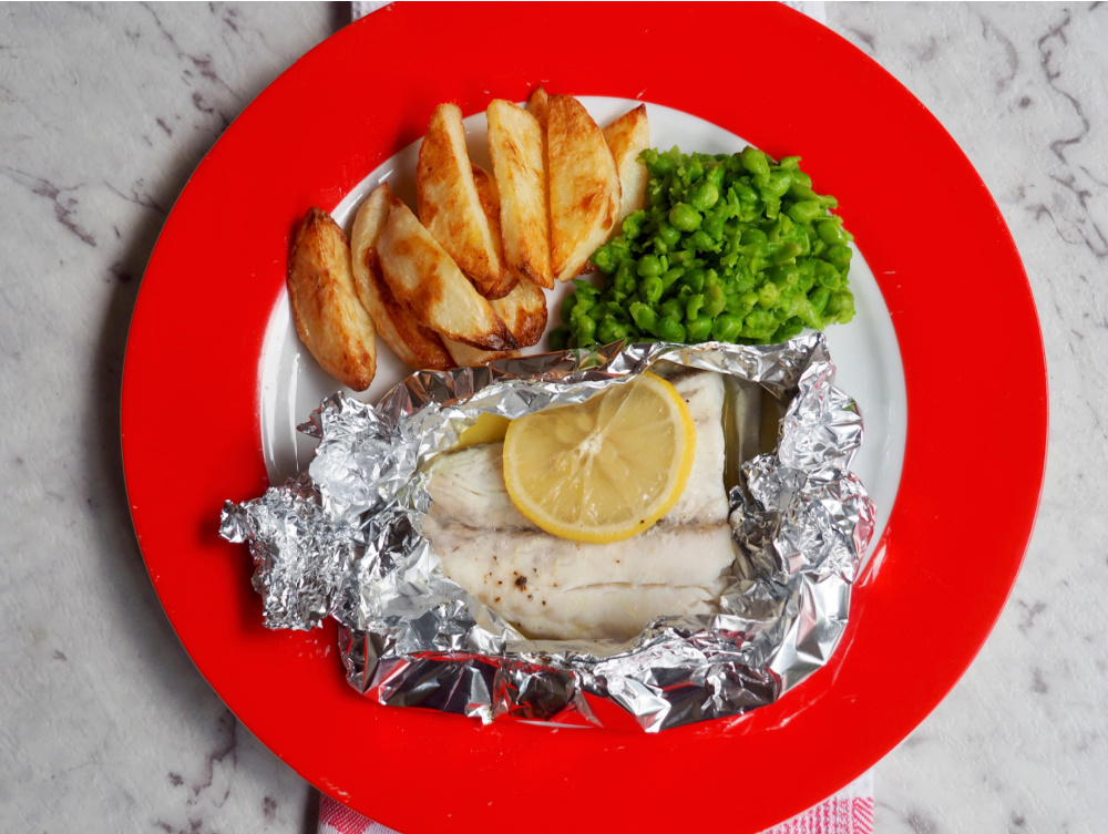 oven baked fish fillets with smashed peas and handcut chips on plate