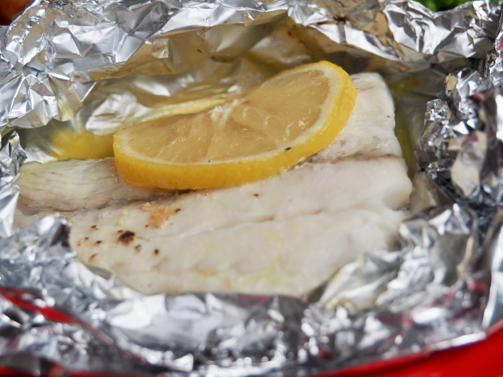 fish with a slice of lemon on top in an open foil parcel