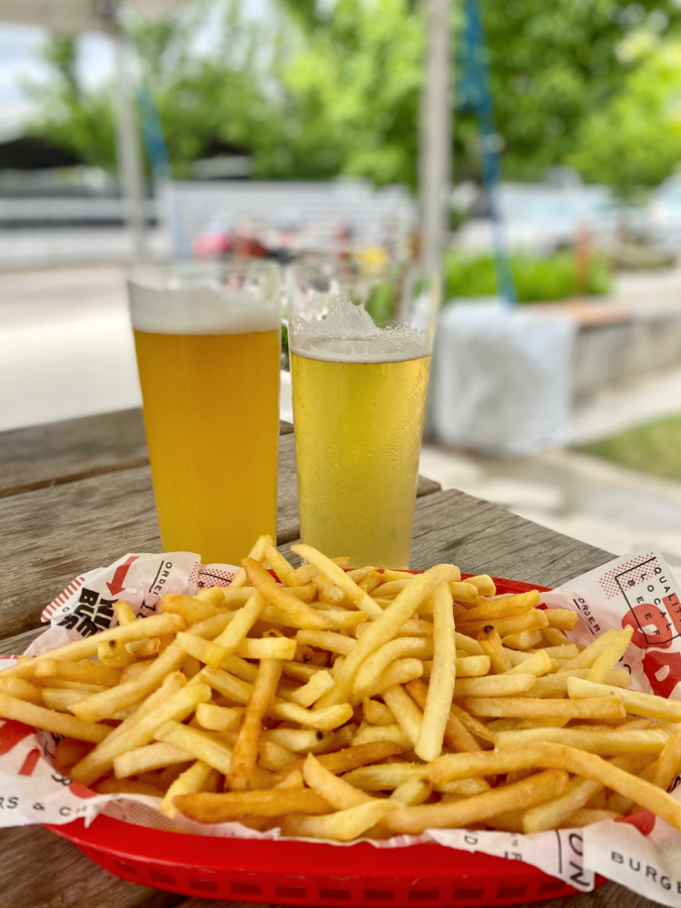 two glasses of beer and basket of fries