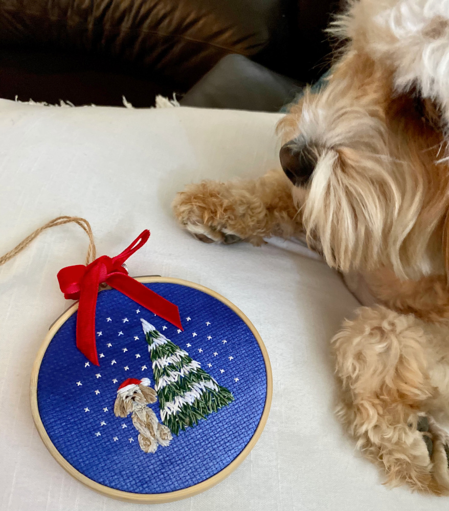 embroidered hoop of a cavoodle sitting next to a christmas tree