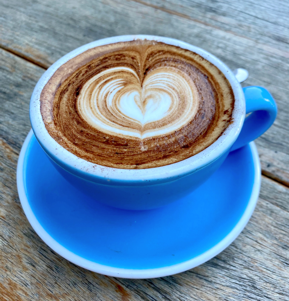 cappucino with coffee art in blue cup