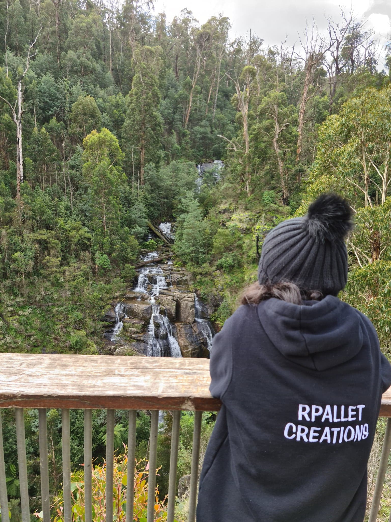 woman looking out at forest from balcony