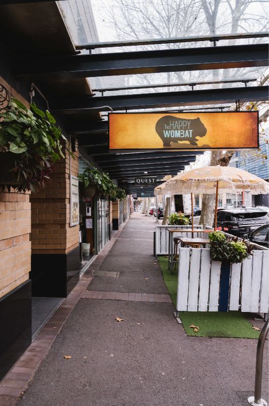 high bar tables and greenery outside bar