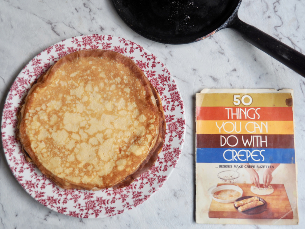 crepe pan recipe book and stack of crepes