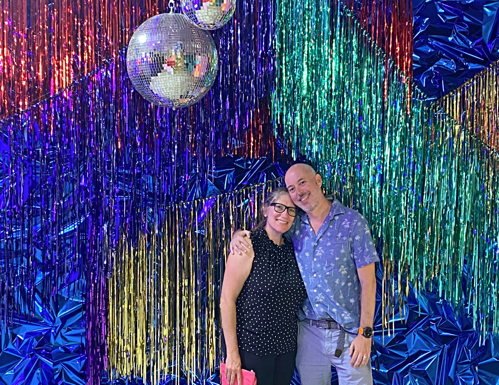 couple standing in front of a glittery background