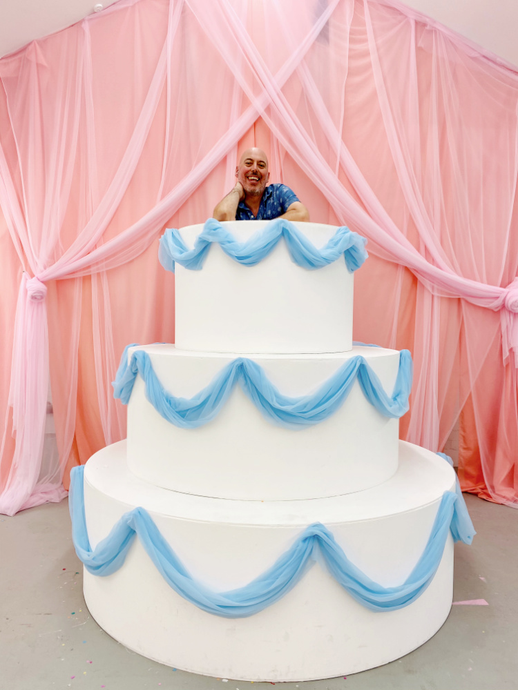 man looking out of life size wedding cake