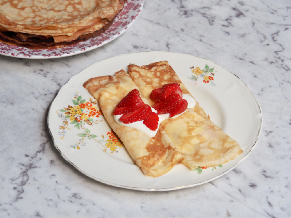 strawberry sour cream crepes with crepes in background