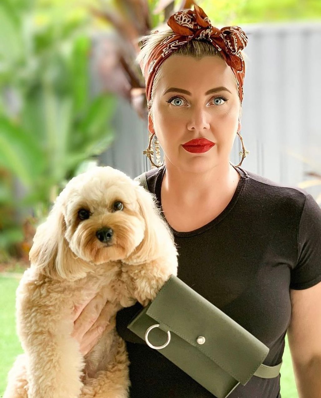 woman holding cavoodle with smart leather treat bag worn across body