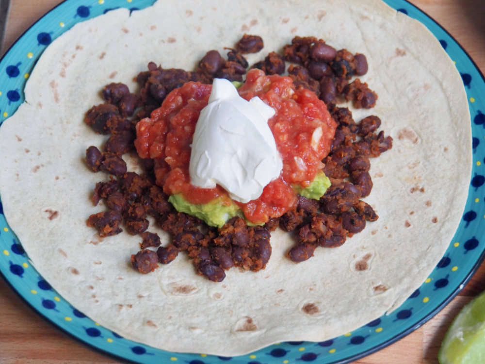 tortilla loaded with black beans sour cream guacamole and sour cream