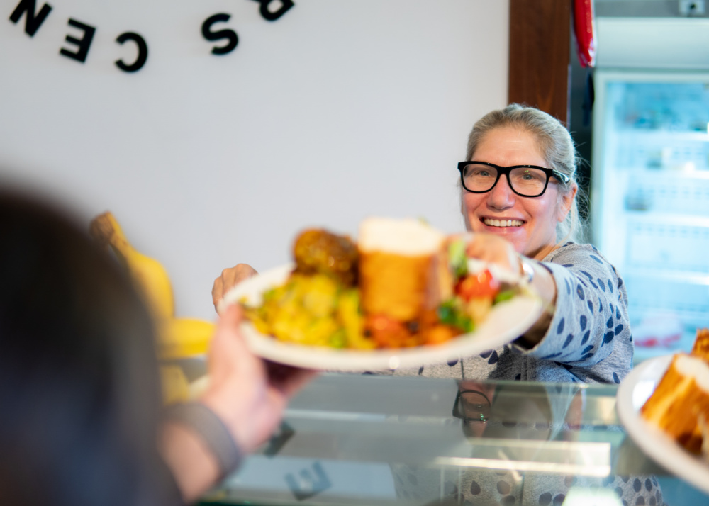 woman serving food at a serving station