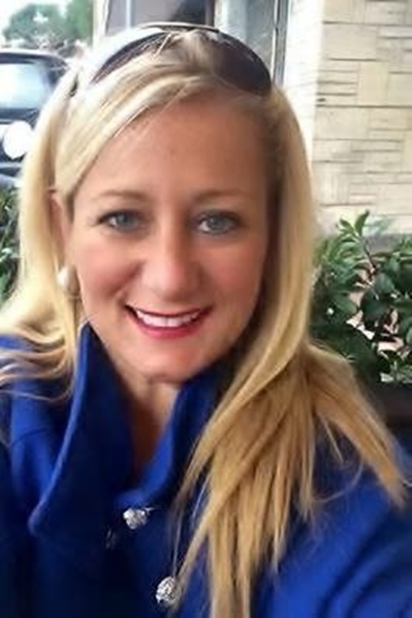 headshot of woman with blonde hair and blue coat