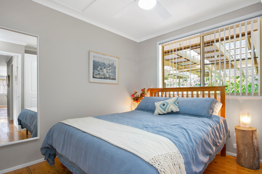 queen size bed with blue bed linen and wooden headboard