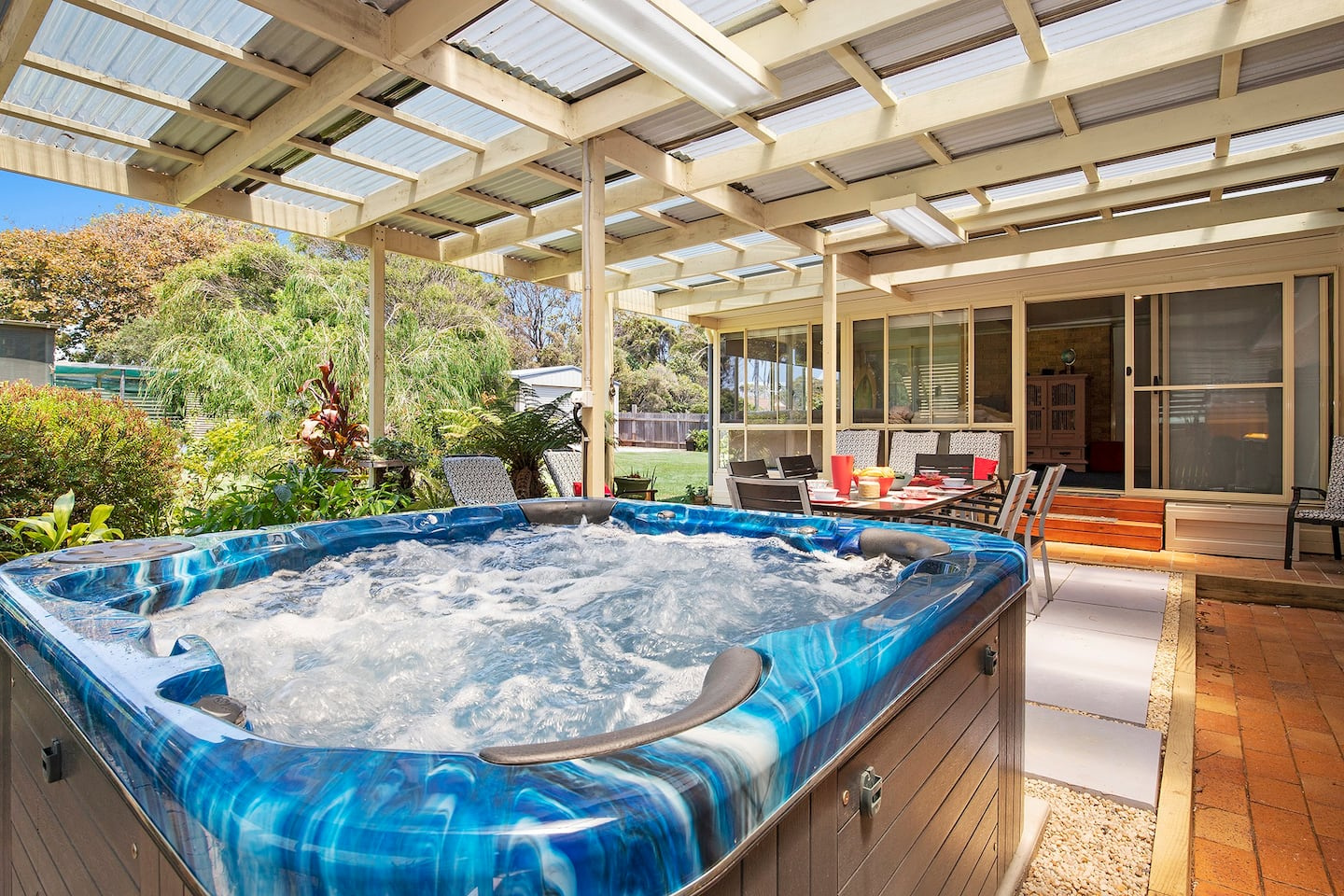 jacuzzi looking out on to covered outside entertainment area and lush garden to side