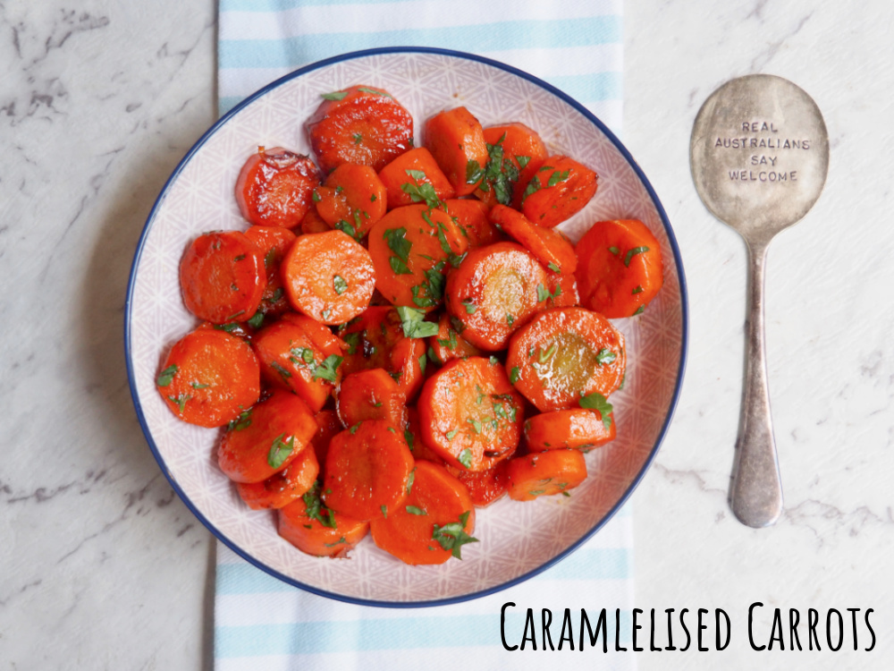 bowl of caramelised carrots next to a spoon that says real Australians say welcome