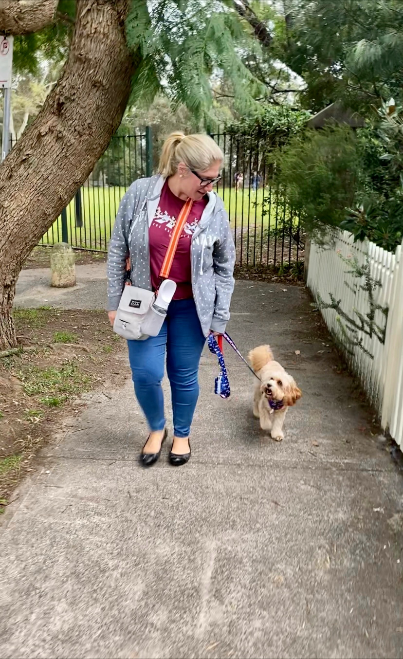 woman and dog looking at each other on dog walk