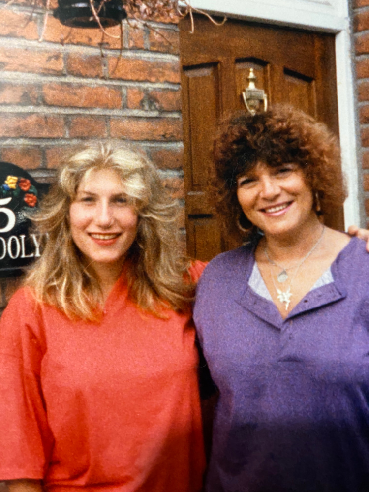 mother and daughter standing outside their front door