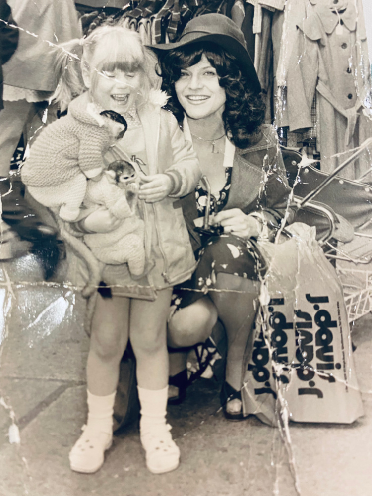 black and white photo of a woman and a child holding 2 monkey