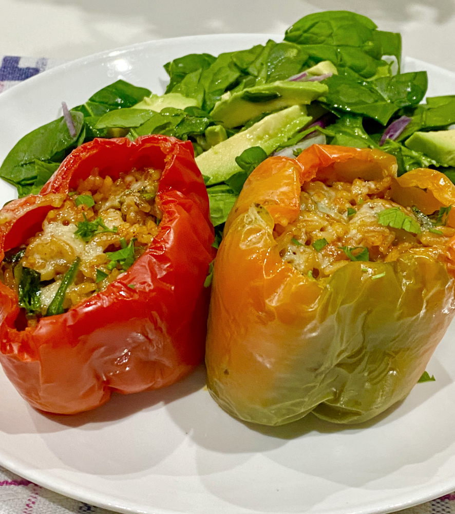 two pesto stuffed peppers on a plate