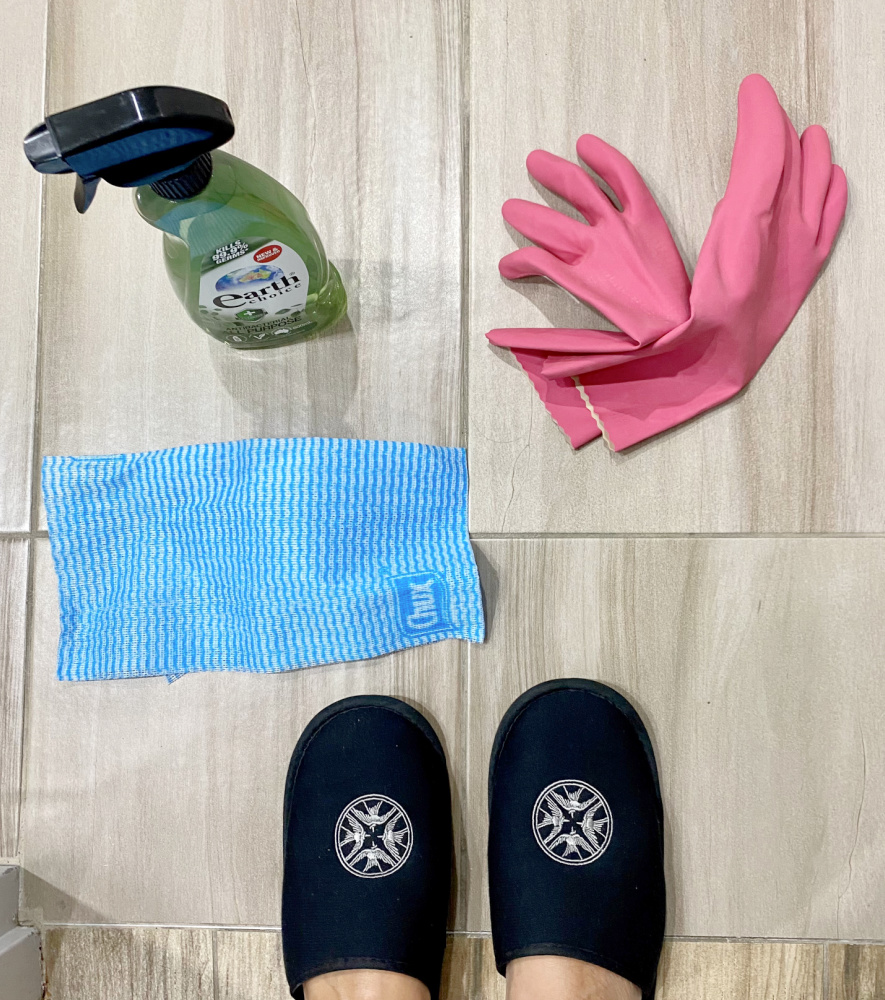 a bottle of cleaning fluid, rubber gloves and j cloth