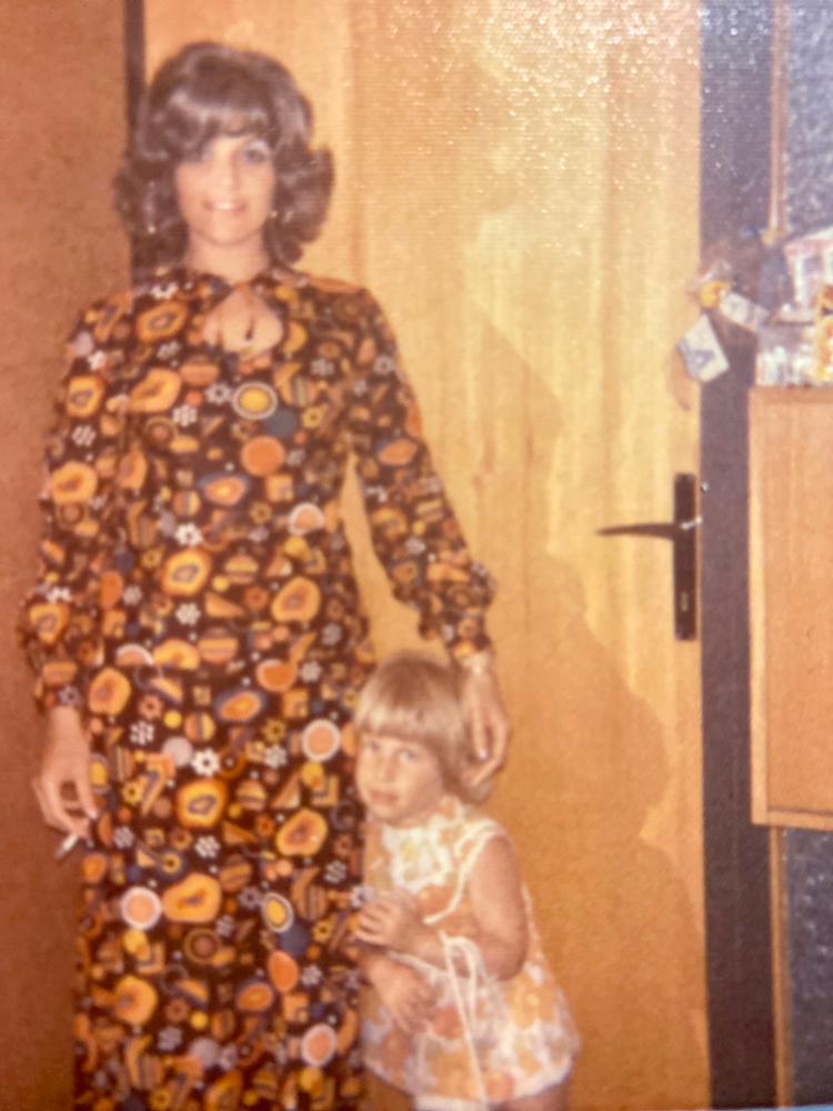 woman in 70s maxi dress with small child next to her