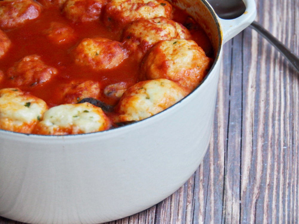 side view of pot of paprika chicken stew with chive dumplings