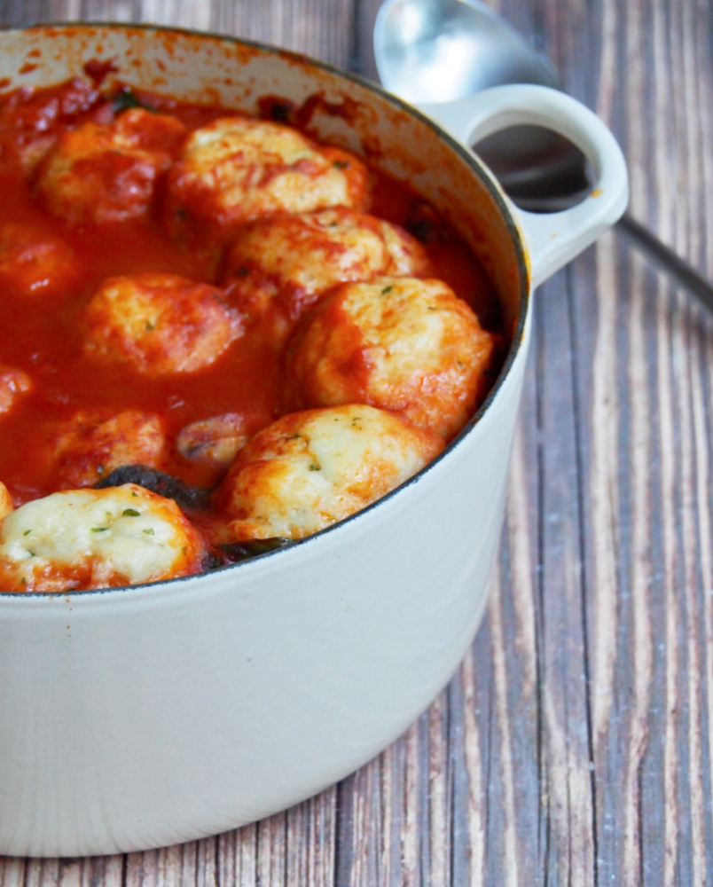 side view of pot of paprika chicken stew with chive dumplings
