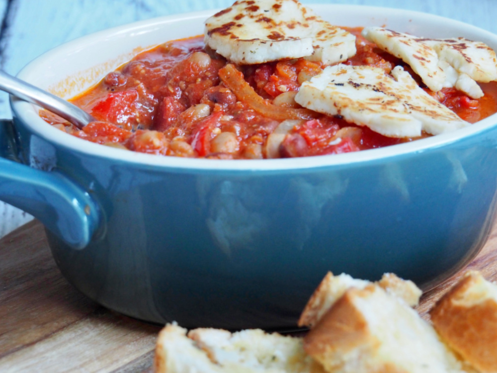 spoon in a pot of halloumi and bean stew