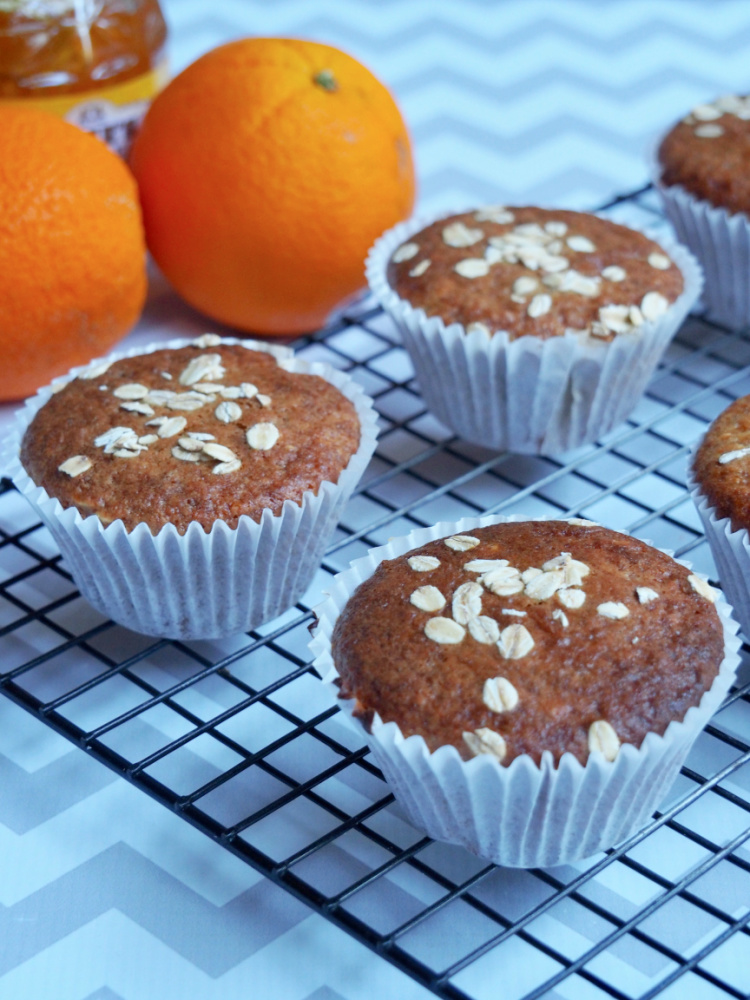 marmalade muffins on cooling rack with oranges in background