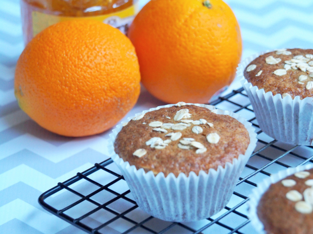 marmalade muffin on cooling rack with oranges and jar of marmalade in background