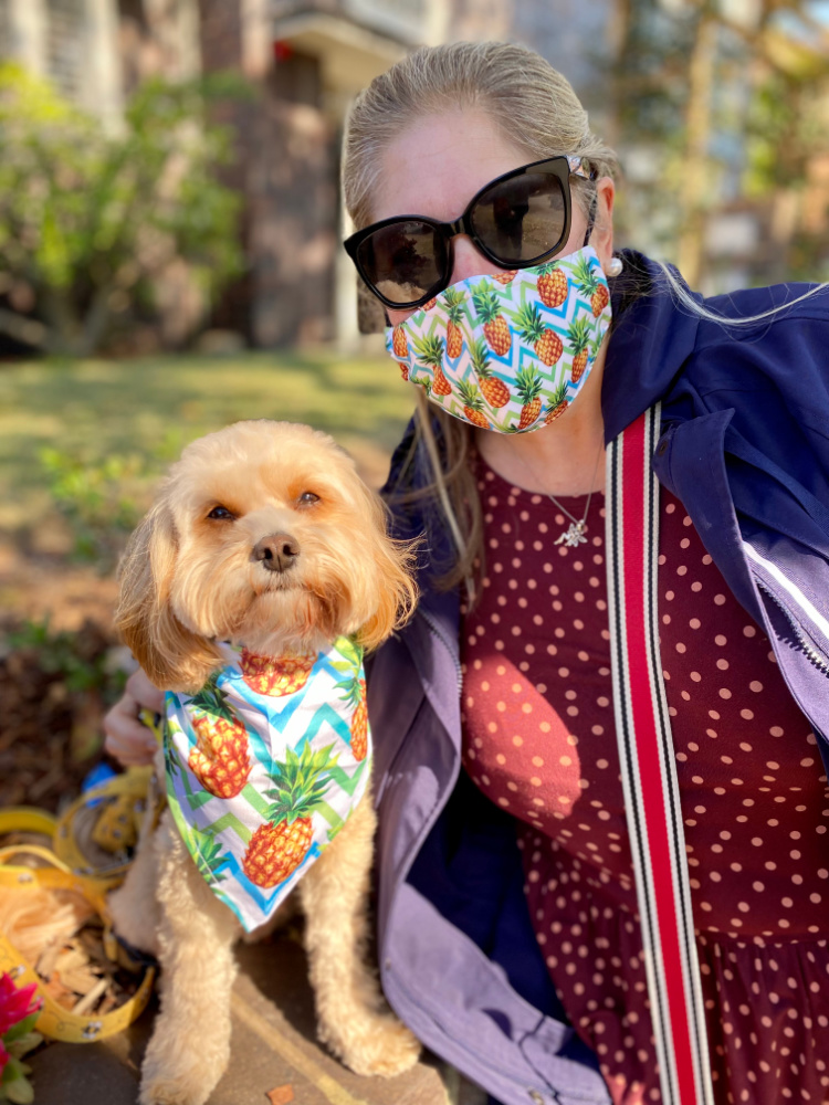 woman and dog wearing matching pineapple mask and bandana