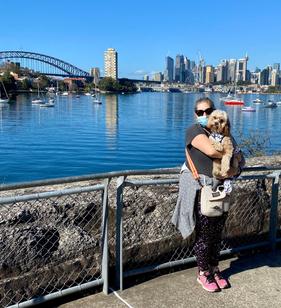 Woman holding dog with sydney harbour and bridge in background