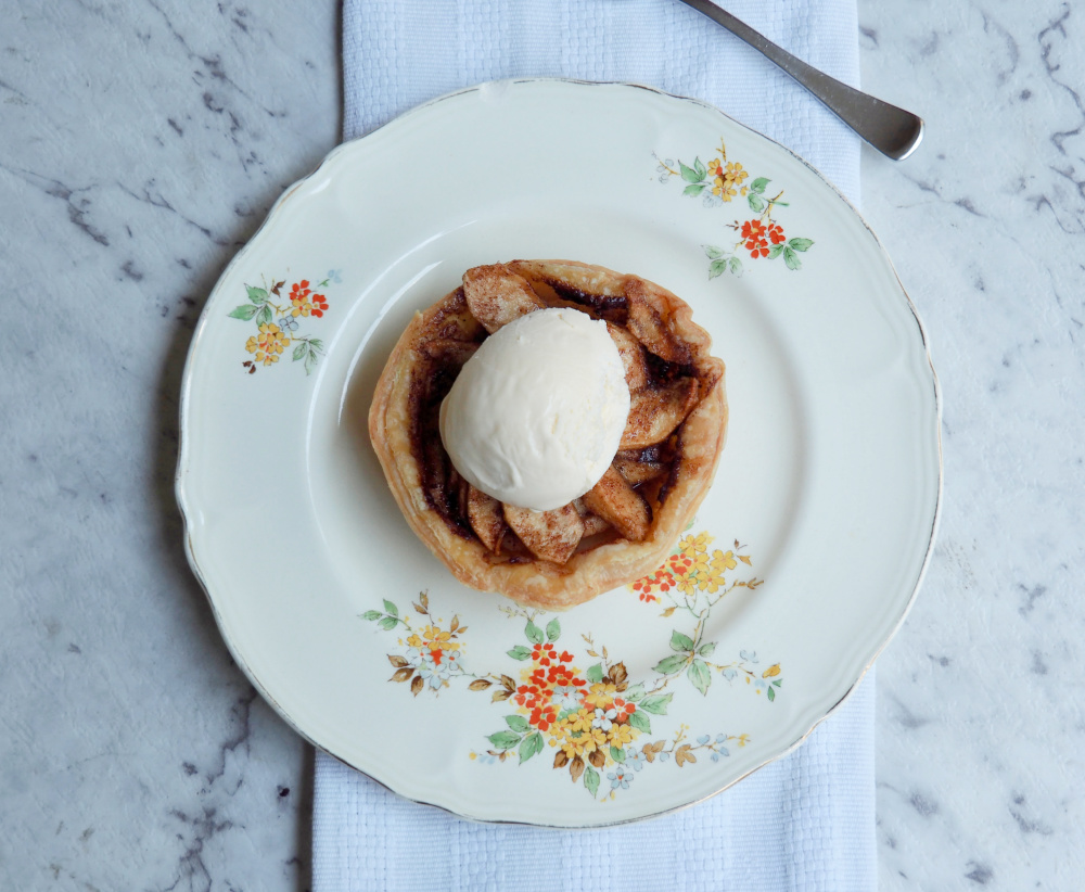 looking down on individual open topped apple pie with ice cream on top