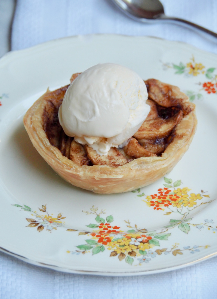 individual open topped apple pie with scoop of ice cream on top