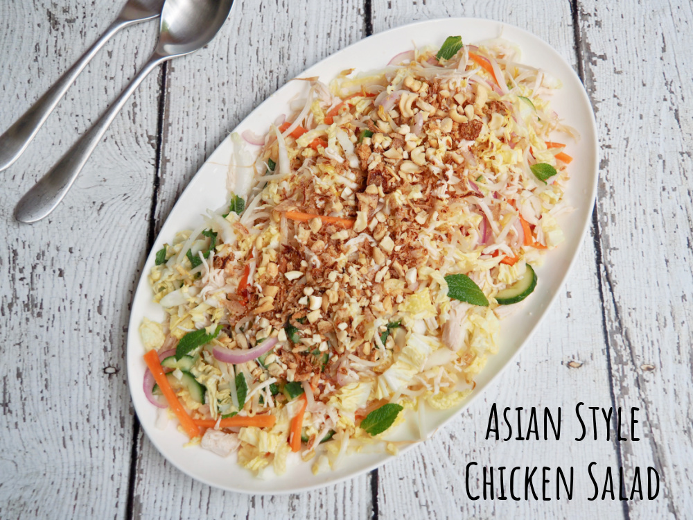 Asian Style Chicken Salad on platter with salad servers