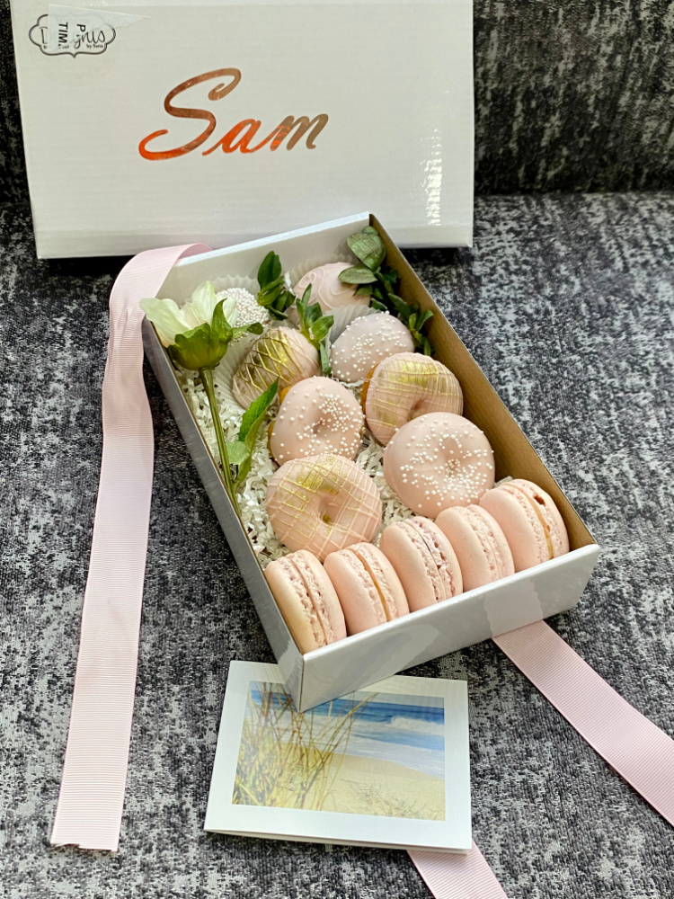 box of pastel pink donuts and macarons