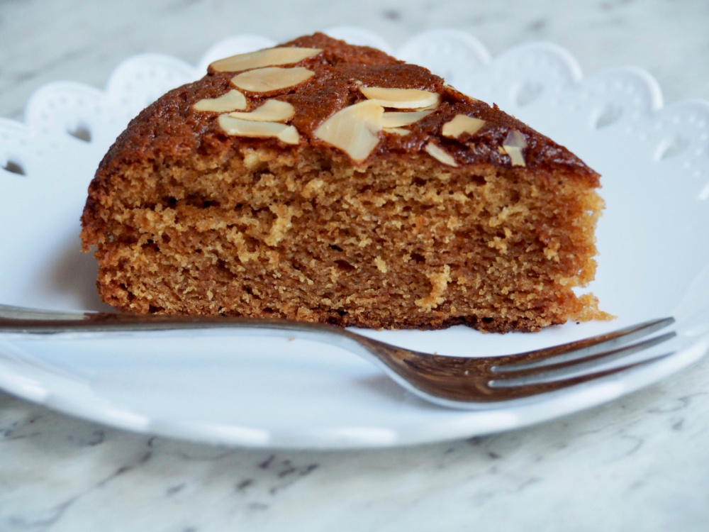 slice of honey cake on white plate with small cake fork